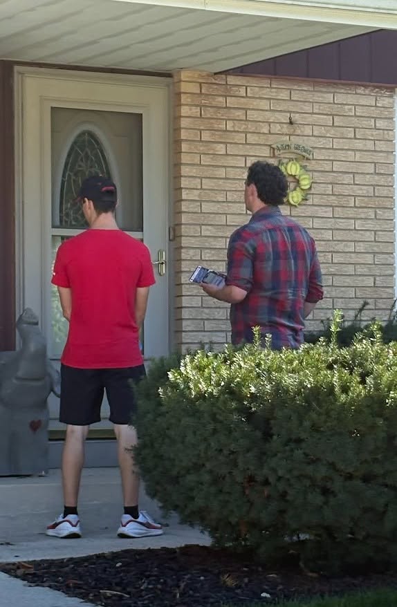 Three volunteers carry Tom Tiffany literature while walking through the community.
